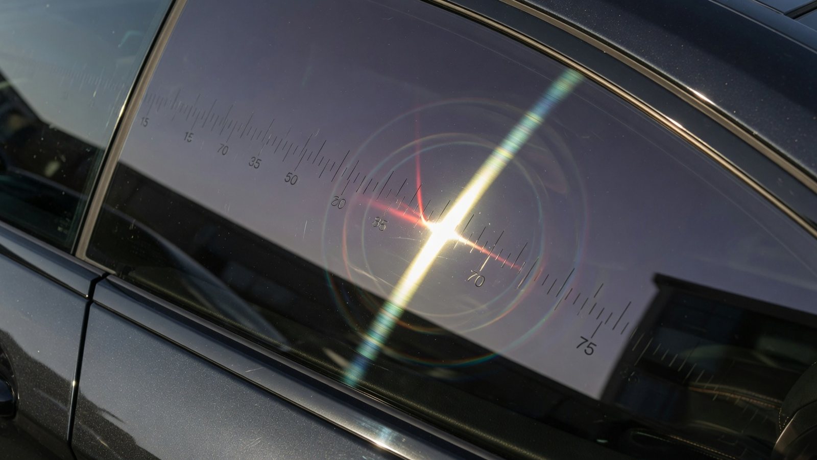 Tinted car side window with gauge-like light reflection for Arizona tint law guidance