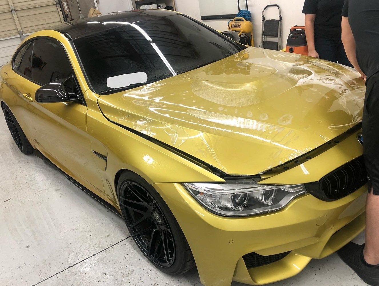 Yellow BMW hood being prepared for clear paint-protection film